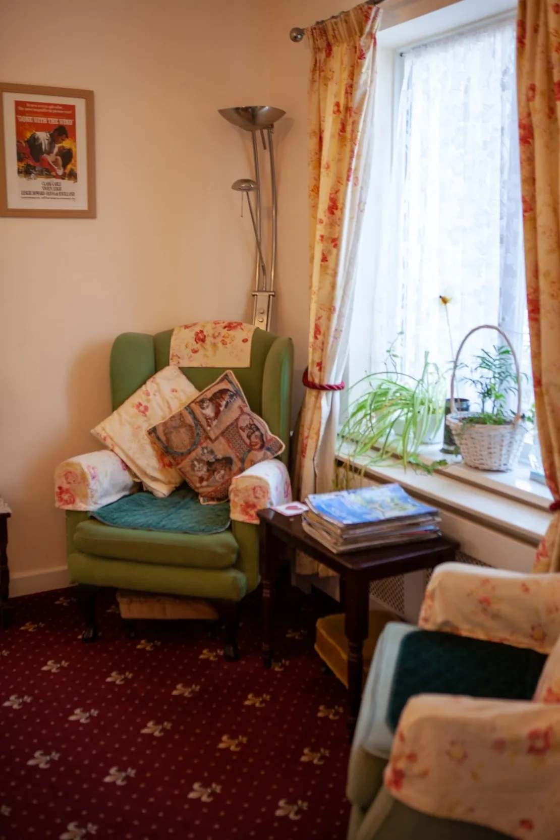 Bright residents' lounge at The Chestnuts with armchairs, cushions and a sunny window
